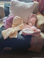 Overall view of both hat-scarf sets and slipper pairs on chair