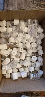 Open box filled with loose white and clear flameless tealight candles