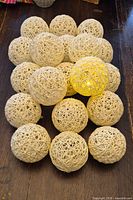 Top view of 19 woven light balls with one lit