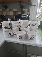 Stacked white ceramic pots with black dragonfly motif