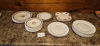 Multiple stacks of assorted vintage plates on countertop