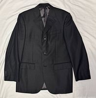 Front view of black Balenciaga blazer laid flat showing two-button closure, lapels and pockets