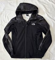 Front view of hoodie showing camo panels, logo, zipper and pockets