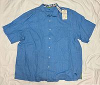 Full front view of blue linen short-sleeve shirt with tags attached