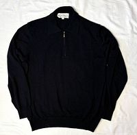 Full view of black quarter-zip sweater laid flat