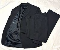 Suit jacket open showing lining and trousers laid on top