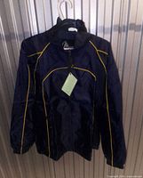 Front view of navy windbreaker with yellow piping and tags attached