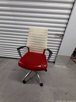 Front view showing red seat, white ribbed back, armrests, wheel base