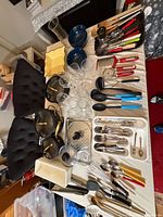 Overview of entire lot on table including pans, glassware, utensils and serveware