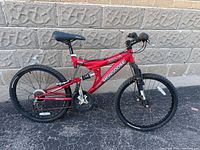 Left side full view of red Mongoose 24-inch mountain bike