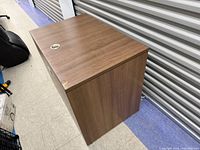 Top and side view of desk showing wood-grain laminate and grommet