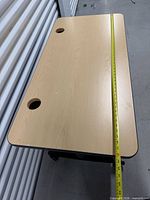 Top view showing rectangular laminate surface, grommet holes, tape for length