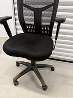 Front view of chair showing mesh backrest, upholstered seat, arms, base