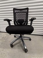 Full front view of Teknion Contessa chair showing mesh back, fabric seat, adjustable arms, caster base