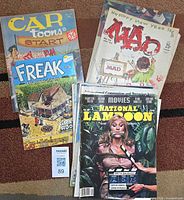 Overview showing CarToons 1964, Freak Brothers #5, MAD Jan 1961 issue, stack of National Lampoon