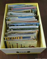 Box filled with vertically arranged vintage postcards