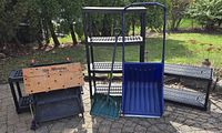Group view of shelving units, Workmate 400 bench, snow scoop and shovel outdoors