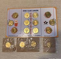 Overall view of 12 medallions in display board with four sealed 2002 coins below