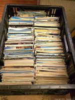 Crate filled with large stacks of postcards