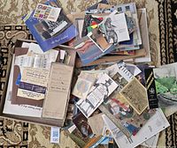 Overview of two piles and box of assorted vintage paper items