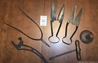 All six antique farm tools laid out