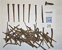 Group of square-head nails spread out showing variety of lengths and rust