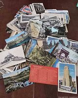 Pile of assorted postcards spread out, showing variety of images and ages