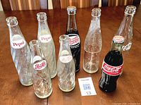 Group shot of all eight glass soda bottles on table