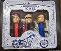 Front view of sealed PEZ tin showing three character dispensers and motorcycle graphic