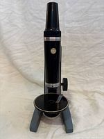 Front view of Bausch & Lomb zoom microscope showing stage and missing slide clip
