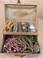 Open jewellery box showing interior tray and assorted jewellery