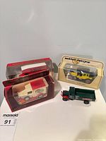 Group shot showing two boxed Models of Yesteryear vehicles and one loose tipper truck