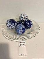Glass bowl holding five blue and white porcelain balls