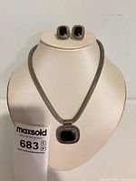 Necklace and earrings displayed on bust