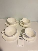 Full set of 4 cups and saucers displayed on surface