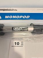 Close-up of Opus OT-S10M label on monopod inside plastic with box