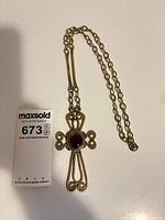 Full view of cross pendant on chain with lot card