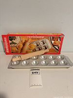 Box, aluminum ravioli tray, wood rolling pin visible
