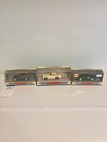 Three boxed die-cast cars side by side