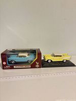 Both die-cast cars together showing colours, boxed item and unboxed on base