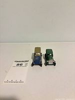 Two small die-cast Tootsietoy cars side by side