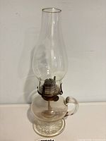 Full view of glass oil lamp with chimney attached