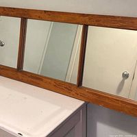 Front view showing three mirrored panes within pine frame