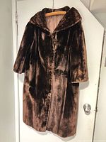 Front view of brown fur coat showing length, collar, and closure