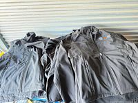 Stack of black Coal Harbour jackets showing overall style and multiple quantities