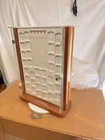 Front view of double-sided jewelry display case on rotating base, keys visible