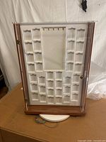 Front view showing clear acrylic door, white compartment tray, keys on ring, wood base