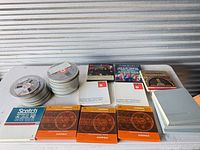 Tabletop view of entire lot showing loose reels, boxed tapes and storage case