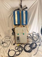 Full view of two blue ballasts mounted above grey control panel with cables