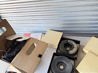 Projector, remote, cords and two slide trays on table